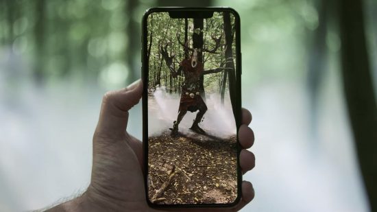 Games like The Witcher 3 - a person holding a phone showing a monster from the Witcher mobile game