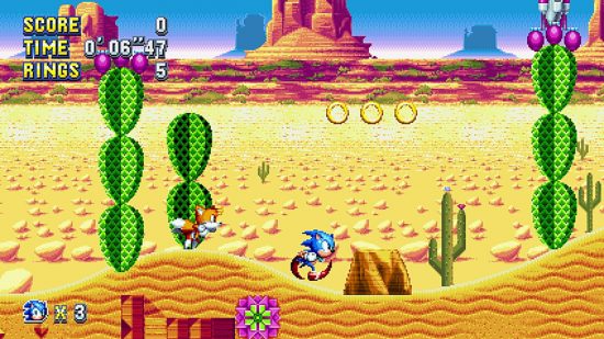 Najlepsze gry Sonic: Zrzut ekranu z gry Sonic Mania Plus przedstawiający Sonica i Tailsa na poziomie pustyni.
