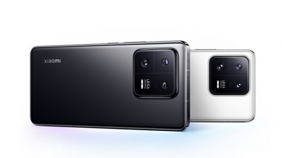 One of the best 5G phones, the Xiaomi 13 Pro, shown twice lying on its side, a black one in front of a white one. We can see a flat glass back and square camera bump in the top left corner of both.