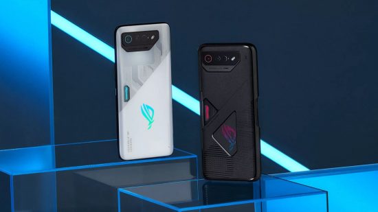 One of the best 5G phones, the Asus ROG Phone 7, shown twice stood upright in an abstract and angular blue and white and black space. The one at the back is white, with an angular design and rhomboid camera cutout. The one in front is the same but in black.