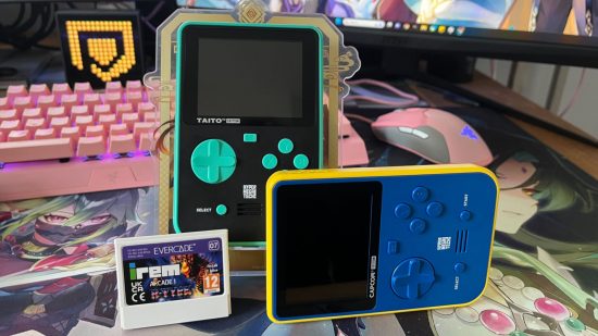 A photo of one of the best portable gaming consoles, the Super Pocket, in both the Capcom and Taito editions, with an Evercade cartridge in front of them