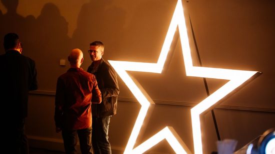 DevelopStar awards 2024 - two people standing next to a large star made of lights