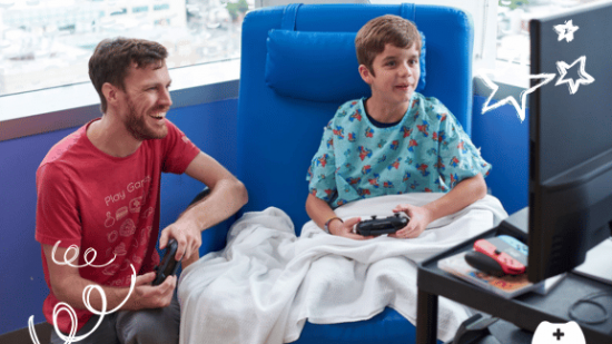 Two people playing games sat in hospital chairs. 