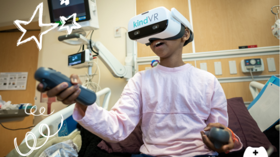 A child in a VR headset, playing in a hospital bed.